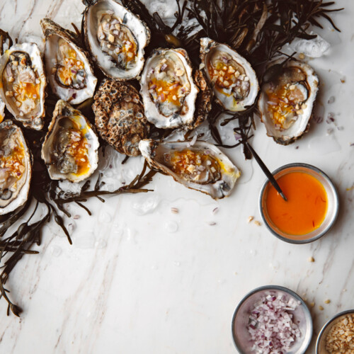 oesters met saffraan-sinaasappeldressing & rode ui