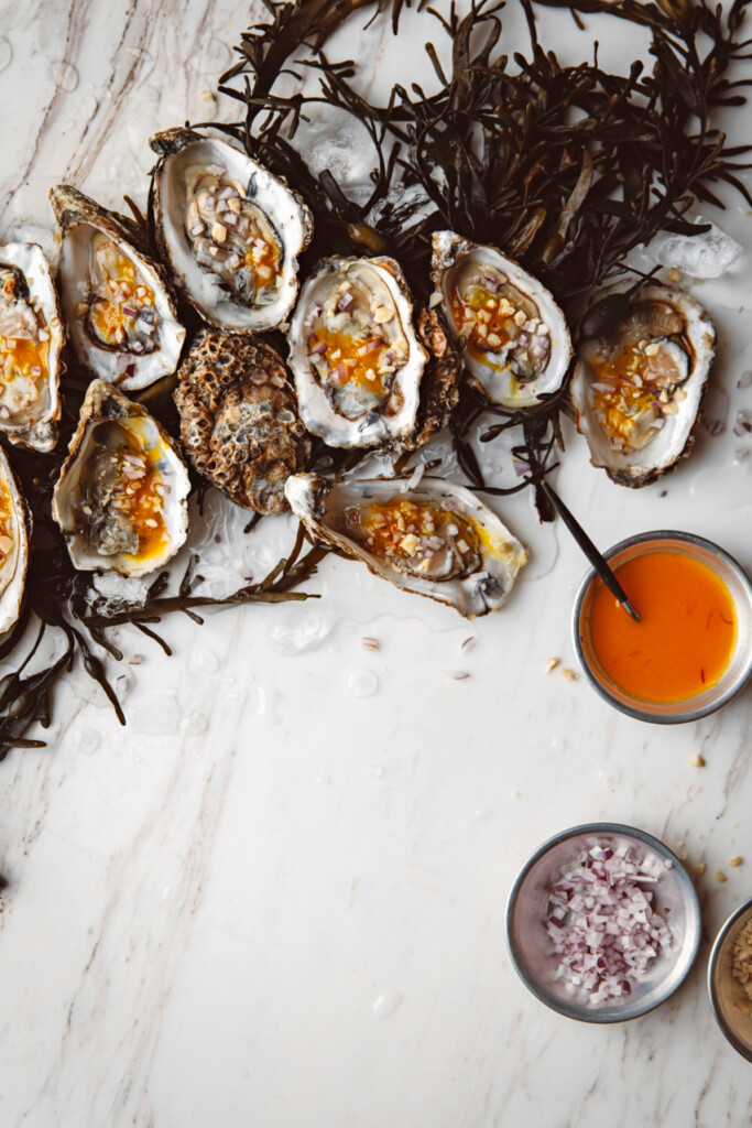 oesters met saffraan-sinaasappeldressing & rode ui