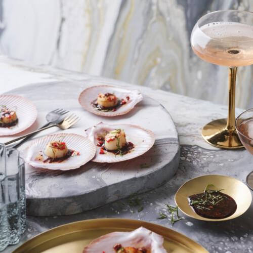 Sint-jakobschelpen met tamari, citroengras en chili gereserveerd op een mooie schelp.